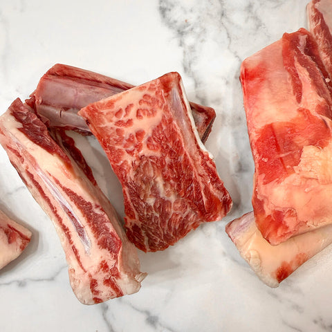 Raw grass-fed beef rib bones for dogs on a marble counter