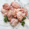 Raw pasture-raised chicken necks for dogs with parsley on marble