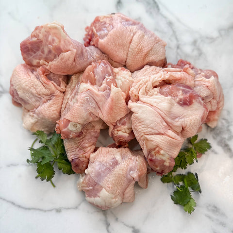 Raw pasture-raised chicken necks for dogs with parsley on marble