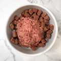 Raw Pet Power Blend meat topper served over dog food in a white bowl