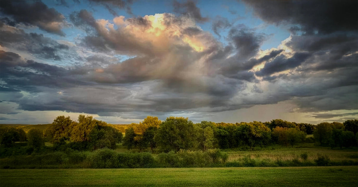 Storm clouds breaking over open Oklahoma pasture at dusk